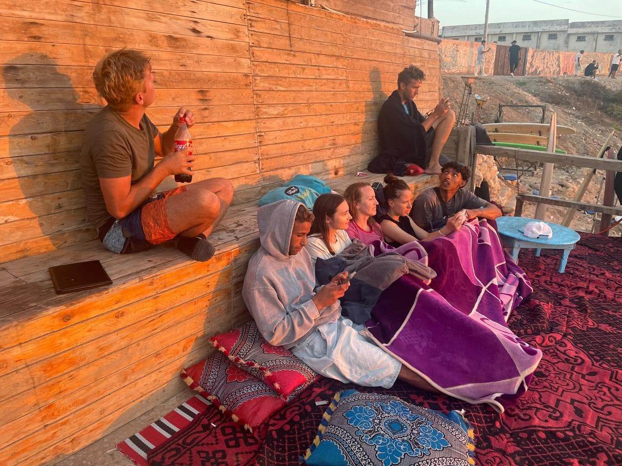 The whole camp crew relaxing on beach cushions at sunset — Family week